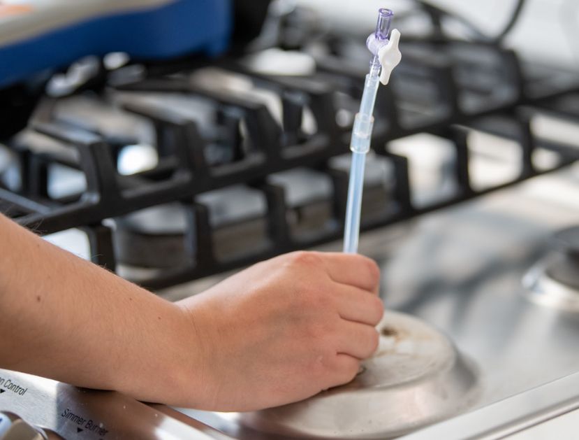 Image of a scientists taking a natural gas sample from a kitchen stove.